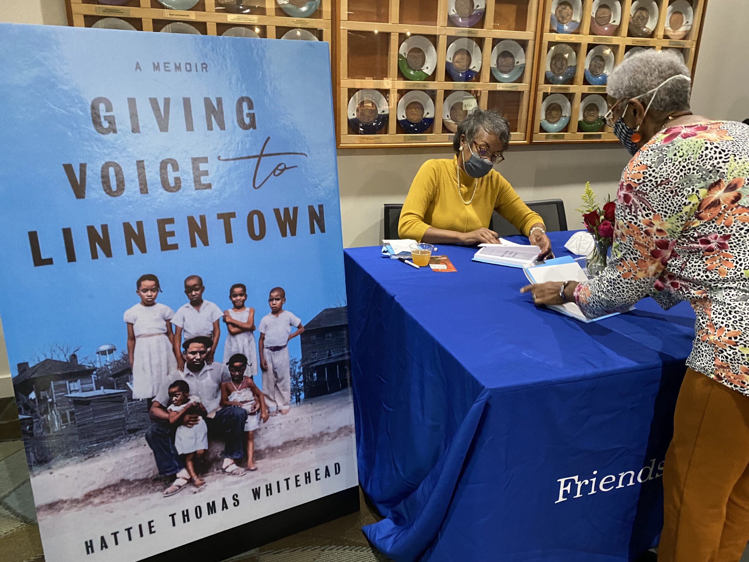 Linnentown descendant Hattie Thomas Whitehead signs a copy of her memoir for a book launch attendee.